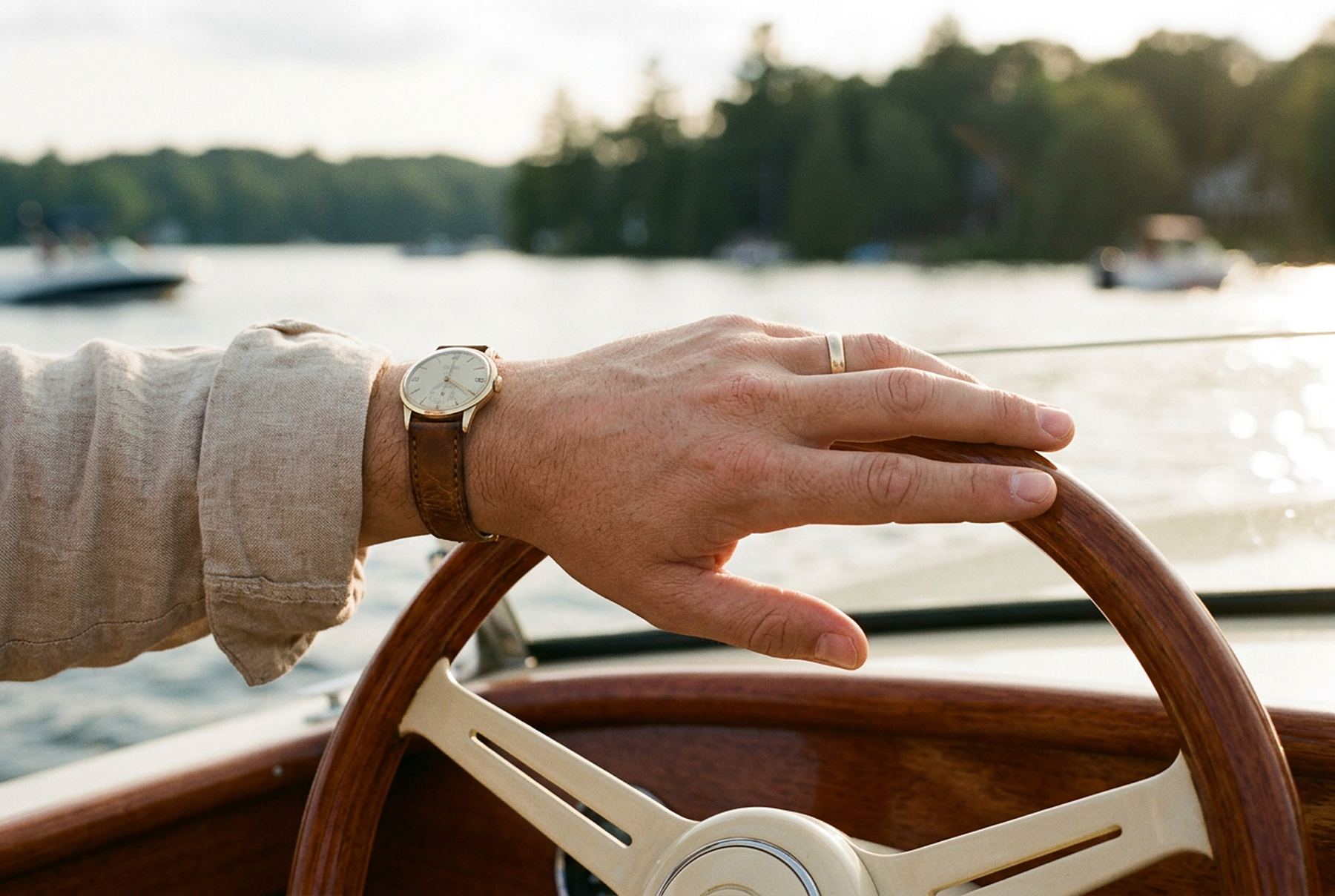 Hands resting on a boat's wheel in late-afternoon light